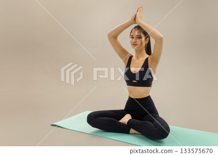 Woman practicing yoga in lotus pose on mat, yoga meditation and stretching fitness routine for wellness, balance and healthy lifestyle, yoga practice and mindful exercise in calm studio space. Woman practicing yoga in lotus pose on mat, yoga meditation and stretching fitness routine for wellness, balance and healthy lifestyle, yoga practice and mindful exercise in calm studio space. 133575670
