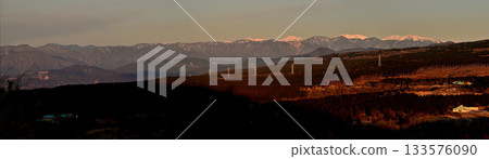 從阿席達卡山脈越前山鳥離機展望台拍攝的日出時分南阿爾卑斯山脈和富士山山麓的全景照片 133576090