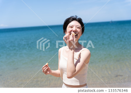 Smiling woman relaxing at the beach 133576346