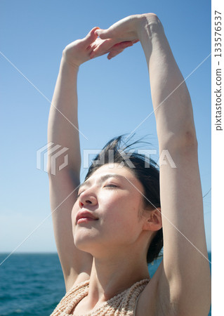 夏天，一位女士在海灘上享受寧靜的時光。 133576537