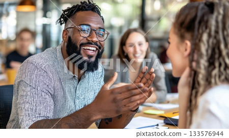 Black man in casual-smart attire speaking confidently in a strategy meeting with a white female colleague 133576944
