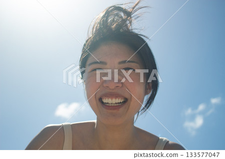 Smiling middle-aged woman looking up at the sky Smiling middle-aged woman looking up at the sky 133577047