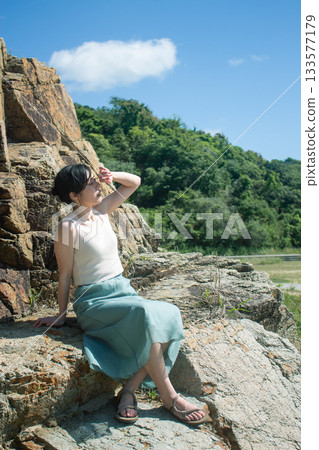 Woman sitting on a rock 133577179
