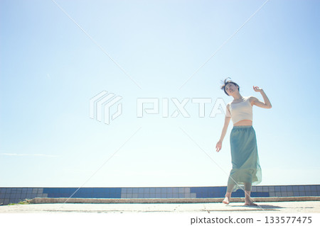 A woman standing by the sea A woman standing by the sea 133577475