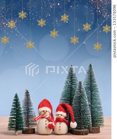 Christmas background with knitted snowmen in red hats and Christmas trees, golden snowflakes and space for text, greetings, promotions, and discounts. Christmas and New Year card. 133578096
