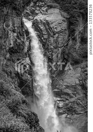 Wild alpine waterfall on Schlatenbach mountain stream. Gschloesstal Valley, Hohe Tauern National Park, East Tyrol, Austrian Alps. Black and white image. Wild alpine waterfall on Schlatenbach mountain stream. Gschloesstal Valley, Hohe Tauern National Park, East Tyrol, Austrian Alps. Black and white image. 133578236