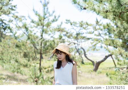 一位身穿白裙的女子站在森林裡。 133578251