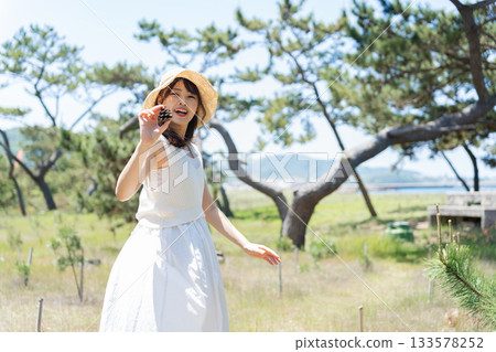 一位身穿白裙的女子站在森林裡。 133578252