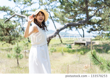 A woman in a white dress standing in the forest A woman in a white dress standing in the forest 133578253