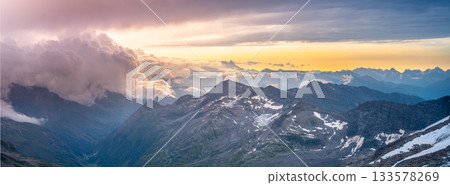 Rocky alpine mountains morning panorama. Cloudy sunrise on summer day. Grossglockner Mountain, Hohe Tauern National Park, Austrian Alps 133578269
