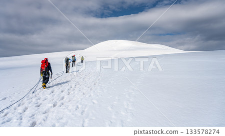 Group of mountaineers on a rope. Summer glacier trekking on Grossvenediger Mountain, Hohe Tauern National Park, Austrian Alps Group of mountaineers on a rope. Summer glacier trekking on Grossvenediger Mountain, Hohe Tauern National Park, Austrian Alps 133578274