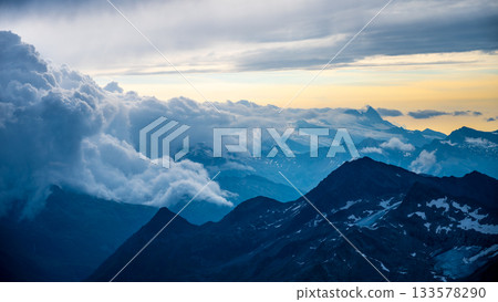 Rocky alpine mountains morning panorama. Cloudy sunrise on summer day. Grossglockner Mountain, Hohe Tauern National Park, Austrian Alps 133578290