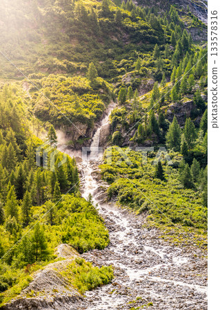 Wild alpine waterfall on Schlatenbach mountain stream. Gschloesstal Valley, Hohe Tauern National Park, East Tyrol, Austrian Alps 133578316