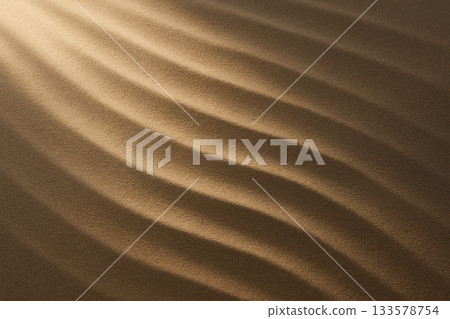 A luxurious background with gently spreading ripples in the sand drawn by golden light 133578754