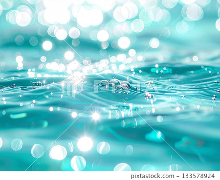 The crystal clear water surface sparkles with turquoise and silver light. 133578924