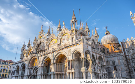 St Marks Basilica impressively dominates the landscape of Piazza San Marco, showcasing its stunning architecture and intricate details against a vibrant blue sky, attracting visitors year-round. St Marks Basilica impressively dominates the landscape of Piazza San Marco, showcasing its stunning architecture and intricate details against a vibrant blue sky, attracting visitors year-round. 133579036