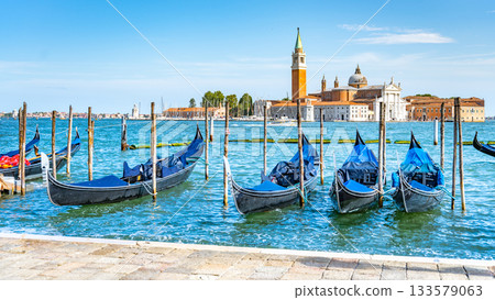 Moored gondolas at St. Mark Square with Church of San Giorgio Maggiore on background. Venice, Italy Moored gondolas at St. Mark Square with Church of San Giorgio Maggiore on background. Venice, Italy 133579063