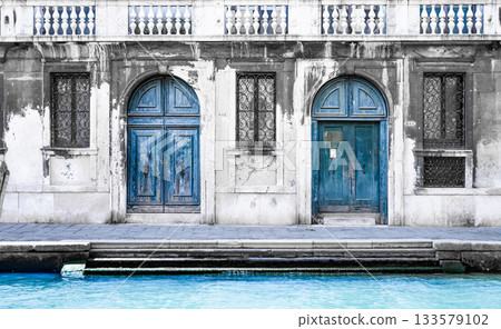 Romantic Venetian nook with two vintage blue wooden doors and windows. Venice, Italy 133579102