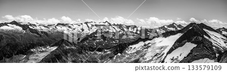 Alpnine rocky peaks panorama on sunny summer day. Austrian Alps, Austria. Black and white image. 133579109