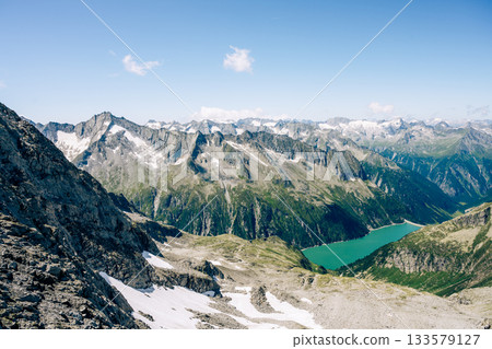 Summer alpine scenery with turquoise blue water reservoir. Zillertal Alps, Austria Summer alpine scenery with turquoise blue water reservoir. Zillertal Alps, Austria 133579127