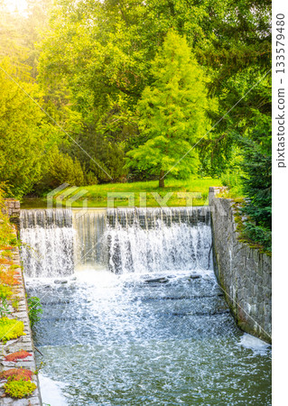 Small double waterfall on the forest stream. Gaden stone sluice in tranquil forest mood. Small double waterfall on the forest stream. Gaden stone sluice in tranquil forest mood. 133579480