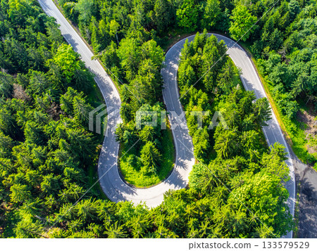Asphalt road serpentine in the forest. Aerial view from drone. 133579529