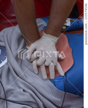 Emergency worker paramedic pressing on sufferers chest for compression, adult and child CPR right hands placement. First aid 133579546