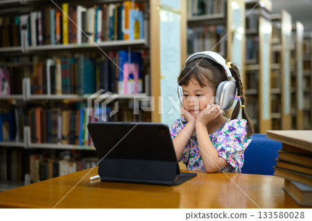 Photo set Asian little girl learning on tablet in library, smiling happiness 133580028