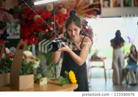 Florist woman photographing her flower products in the shop Florist woman photographing her flower products in the shop 133580076