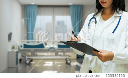 Female doctor in confident with pen and chart board in hand on hospital background 133580133