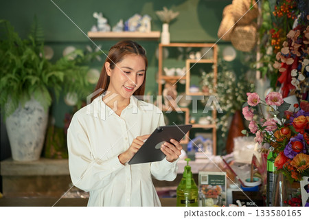 Owner small business managing flower stock with a digital tablet Owner small business managing flower stock with a digital tablet 133580165