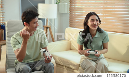Happy couple playing video games together at home 133580170