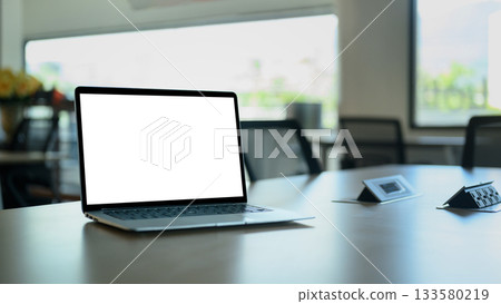 Laptop computer on meeting table with empty screen. Laptop computer on meeting table with empty screen. 133580219