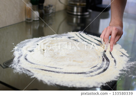 Making Fresh Yeast Dough by Hand with Flour on Kitchen Table, Close Up Process 133580339