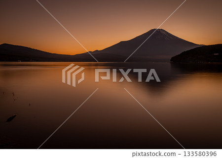Mount Fuji reflected in Lake Yamanaka at dusk, with the calm waters dyed golden Mount Fuji reflected in Lake Yamanaka at dusk, with the calm waters dyed golden 133580396