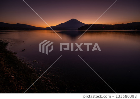夕陽西下,富士山的輪廓在山中湖上若隱若現,構成一幅寧靜祥和的景象。 夕陽西下,富士山的輪廓在山中湖上若隱若現,構成一幅寧靜祥和的景象。 133580398