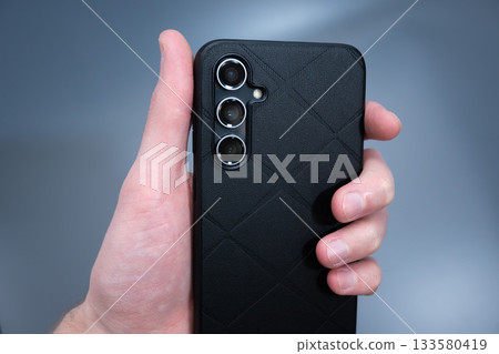 Smartphone in Black Leather Case in Hand Smartphone in Black Leather Case in Hand 133580419