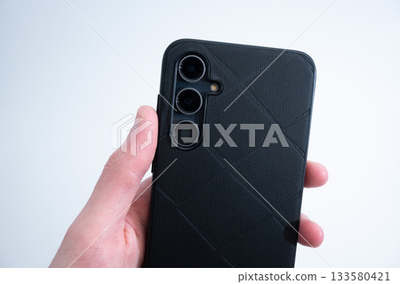 Smartphone in Black Leather Case in Hand Smartphone in Black Leather Case in Hand 133580421