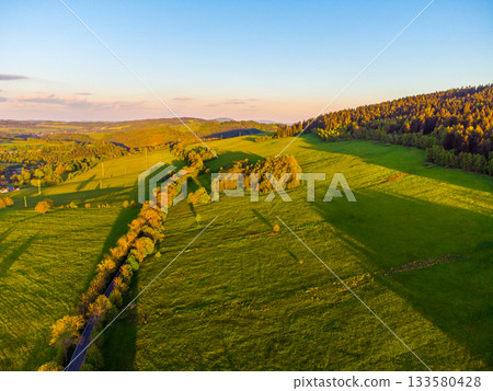 Green rural landscape of Northern Bohemia at susnet time. Aerial view from drone. 133580428
