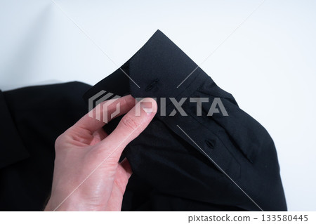 Hand Buttoning Cuff on Black Shirt Hand Buttoning Cuff on Black Shirt 133580445