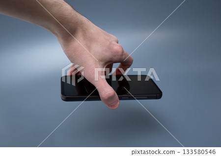 Modern smartphone with triple camera in hand on blue background for advertising Modern smartphone with triple camera in hand on blue background for advertising 133580546