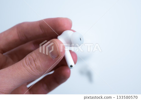 Hand Removing White Earbud from Case Hand Removing White Earbud from Case 133580570