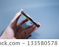Hand Holding Smartphone in Transparent Case 133580578