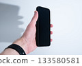 Smartphone in Black Leather Case in Hand 133580581