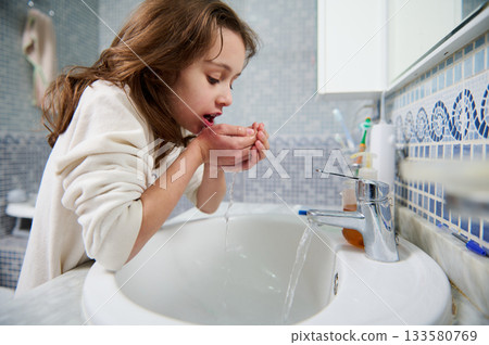 Young Girl Washing Hands at Bathroom Sink With Running Water, Cleanliness and Care Young Girl Washing Hands at Bathroom Sink With Running Water, Cleanliness and Care 133580769