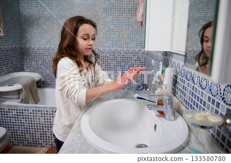 Young Girl Washing Hands At Bathroom Sink Demonstrating Hygiene And Cleanliness At Home 133580780