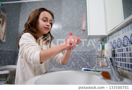 Young Girl Washing Hands At Bathroom Sink For Clean Hygiene Routine 133580781