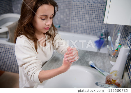 Young Girl Washing Hands With Soap In Bathroom As Part Of Daily Hygiene Routine 133580785