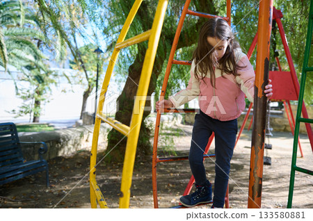 Girl Climbing Play Structure At Sunny Park Playground For Outdoor Fun Girl Climbing Play Structure At Sunny Park Playground For Outdoor Fun 133580881
