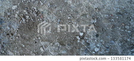 Close-up of a gray-black lava texture on the ground. Porous, cracked, and stony, perfect as a stock texture or photo background. Impression of molten rock. 133581174